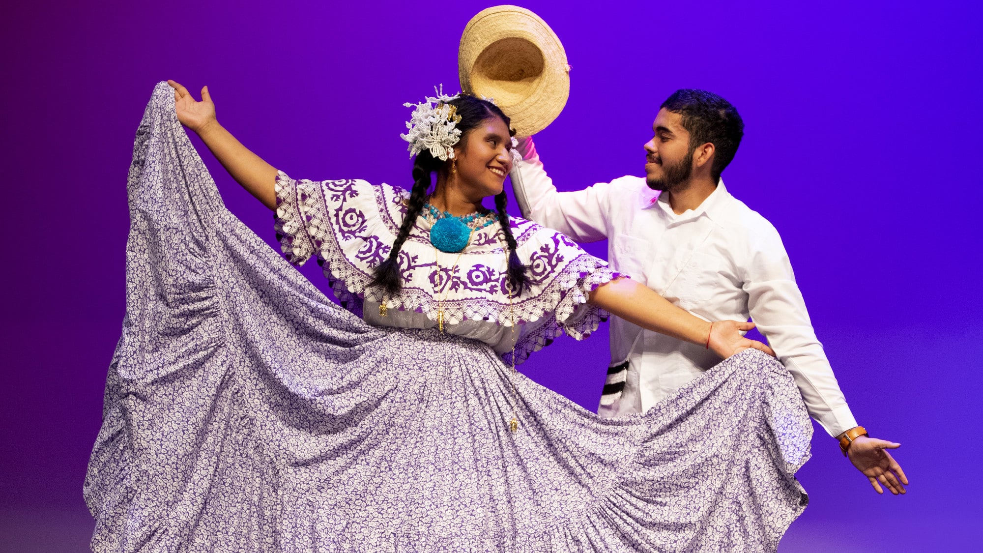 Two students perform a traditional Panamanian dance on stage